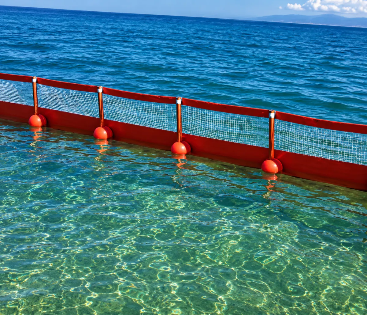 Barrera de contención flotante roja en zona costera