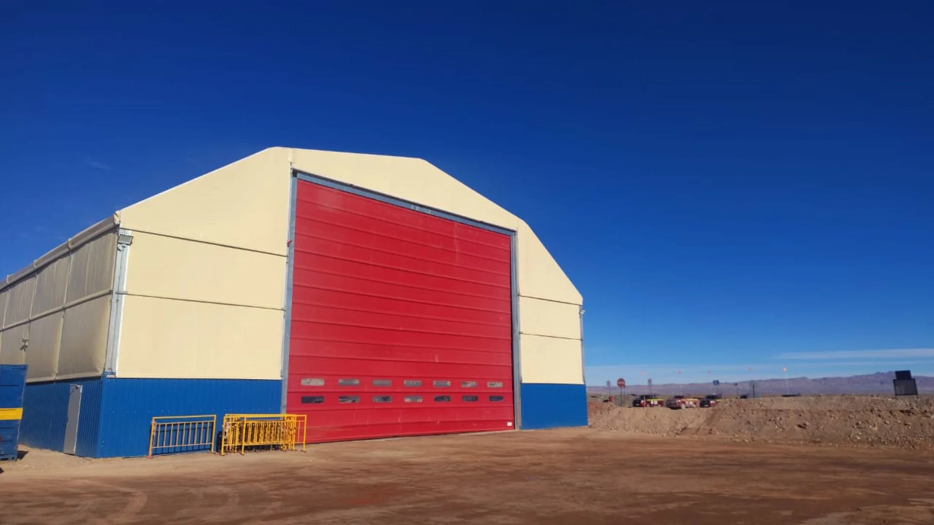 Carpa poligonal exterior con puerta industrial roja