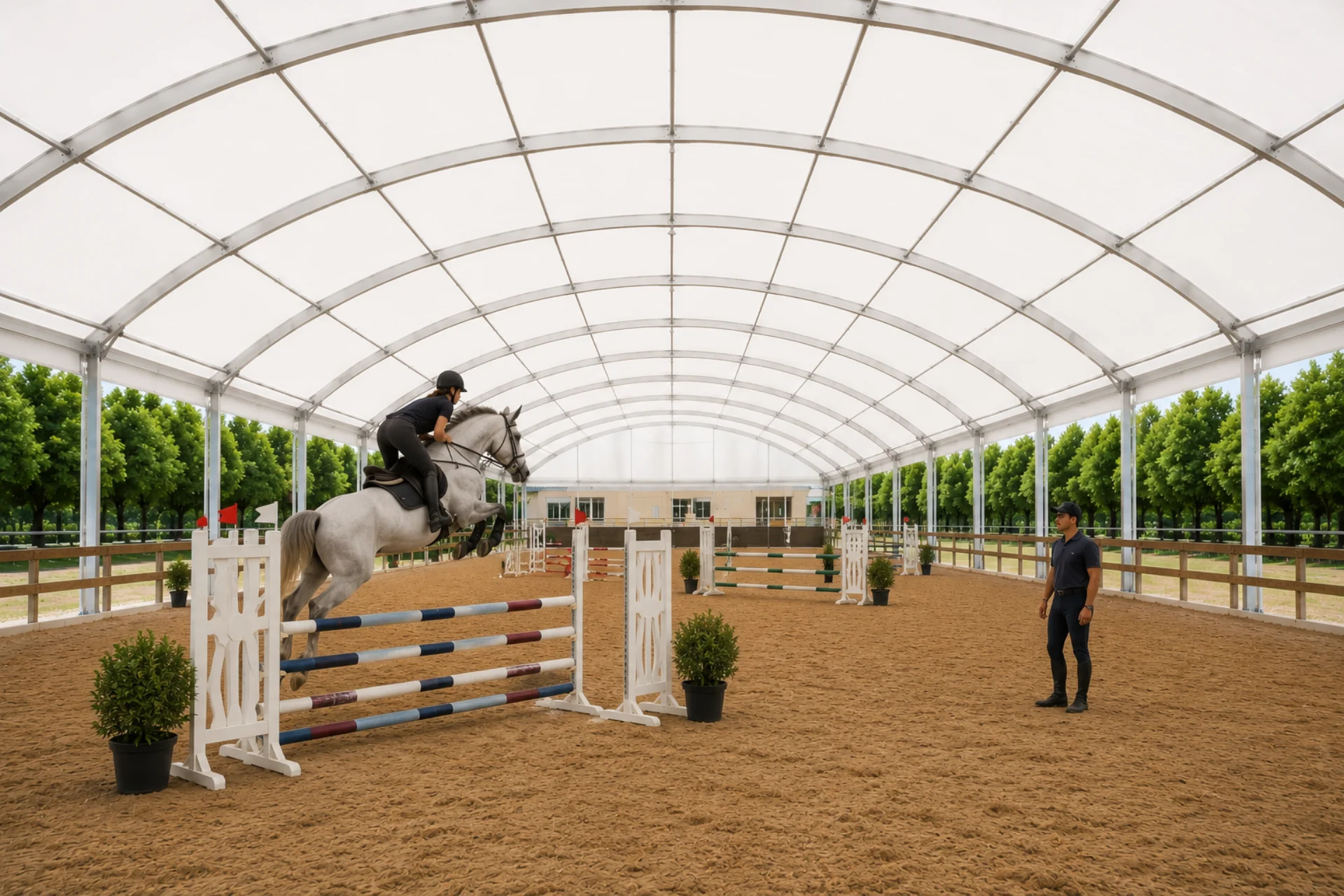 Pista cubierta de salto con techo abovedado y jinete saltando obstáculo