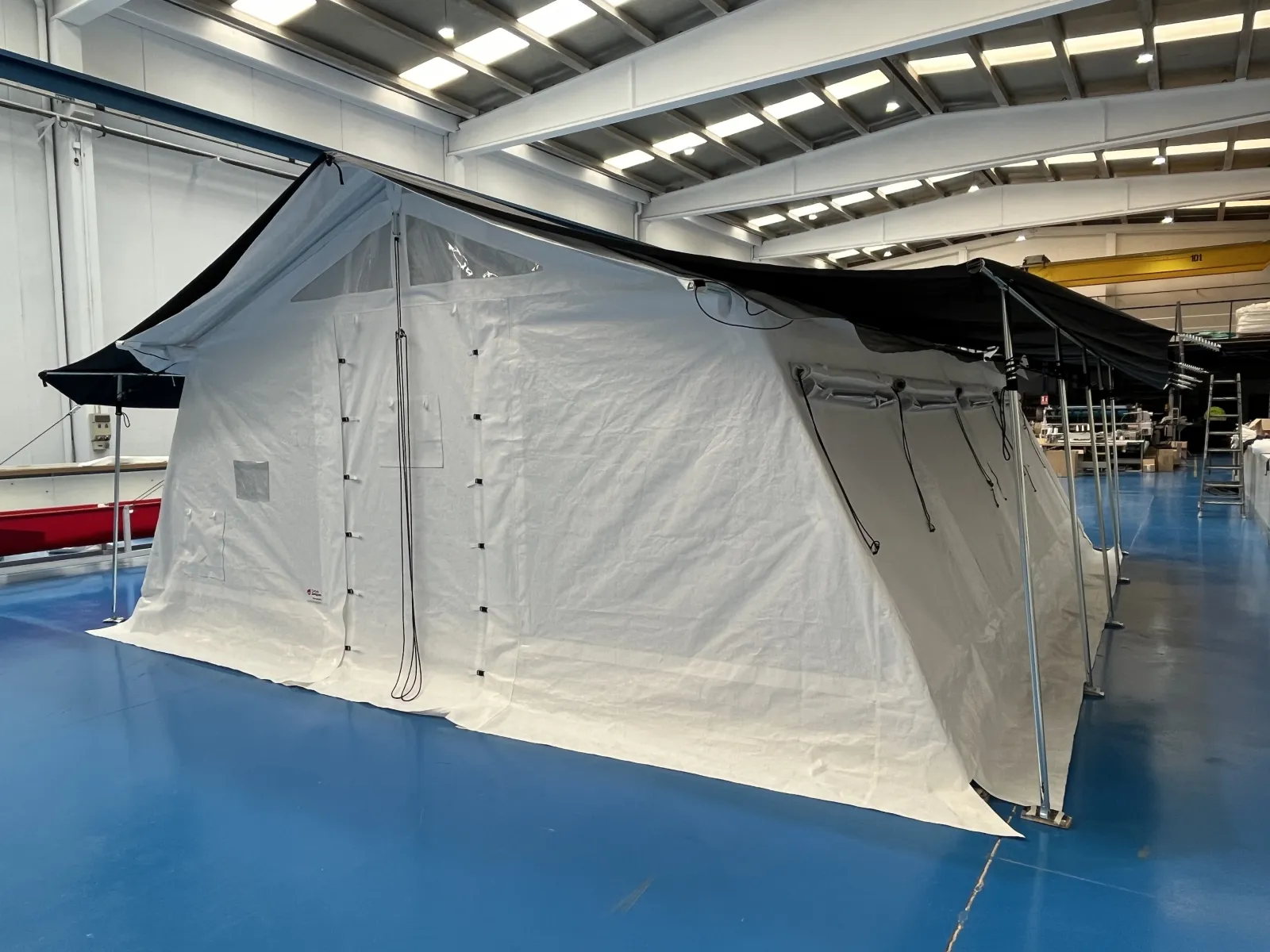 Carpa modular blanca de emergencia vista lateral con voladizo