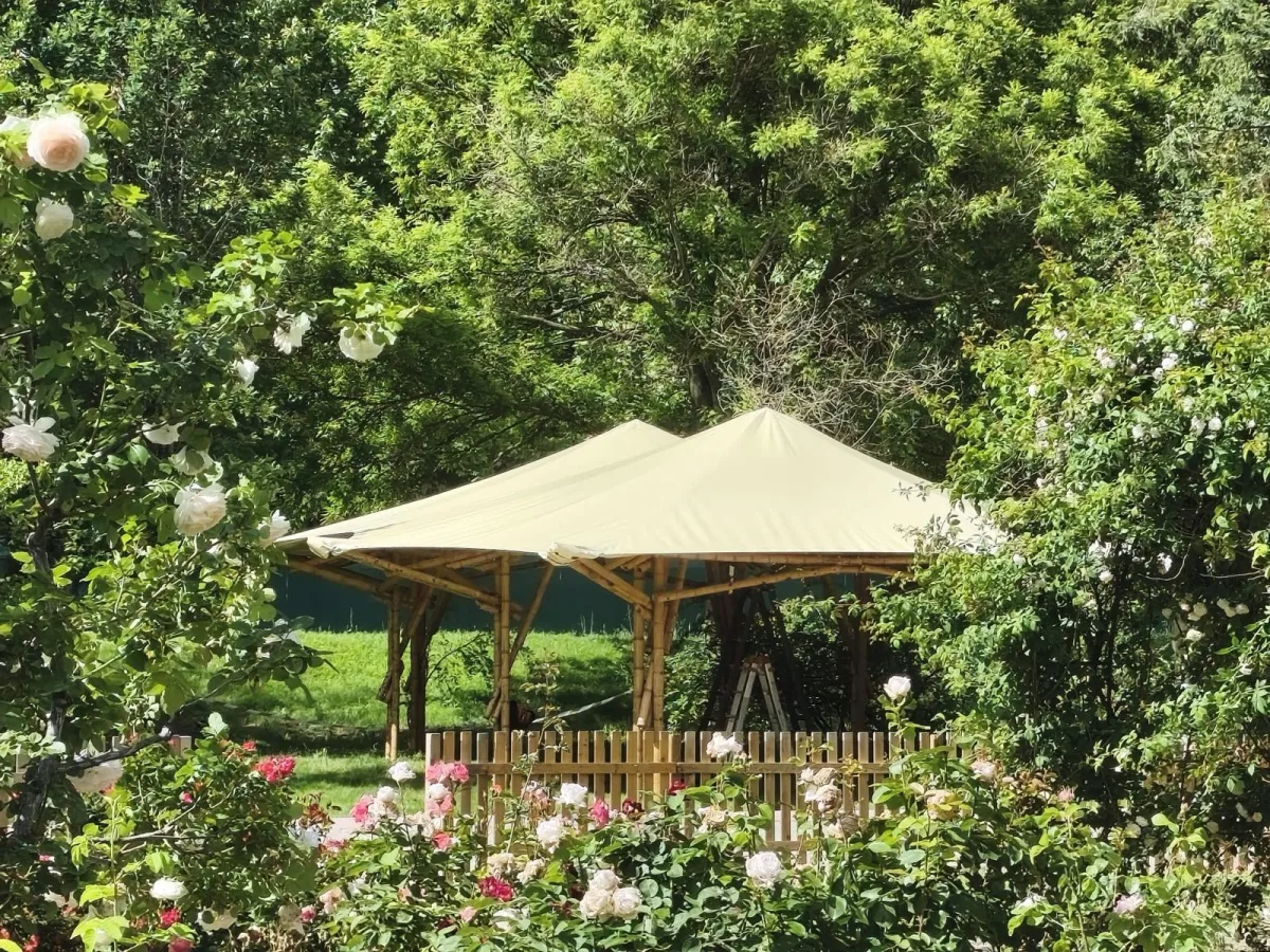 Jaima especial con estructura de madera y cubierta textil en jardín