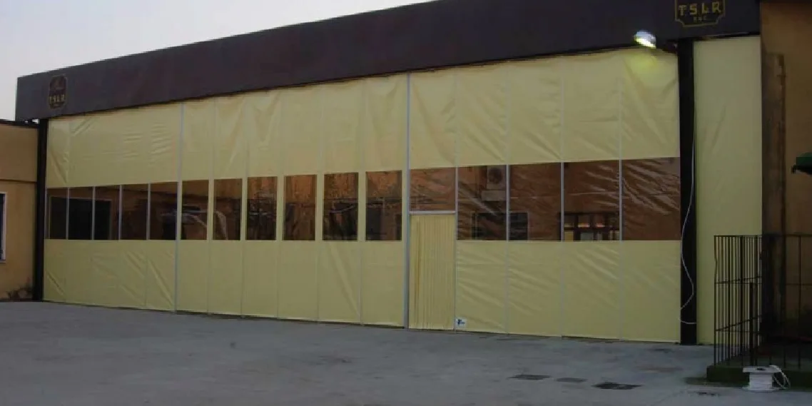 Cortina industrial textil con ventanas cerrando una nave